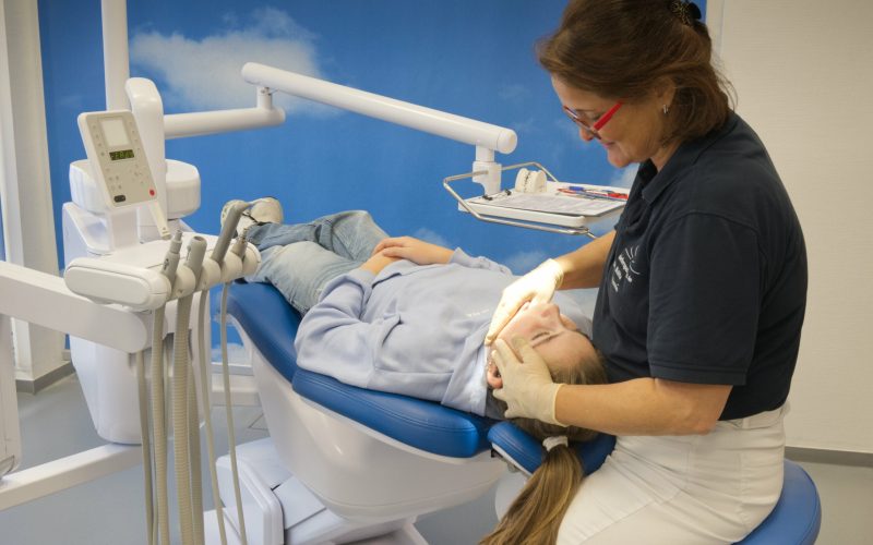 Kieferorthopädin prüft den Biss einer Patientin im Behandlungsstuhl.